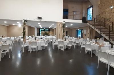 Salle à manger lumineuse avec table en bois, chaises colorées, cuisine ouverte et décoration sobre.