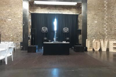 Salle à manger lumineuse avec table en bois, chaises colorées, cuisine ouverte et décoration sobre.
