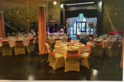 Salle à manger lumineuse avec table en bois, chaises colorées, cuisine ouverte et décoration sobre.