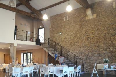 Salle à manger lumineuse avec table en bois, chaises colorées, cuisine ouverte et décoration sobre.