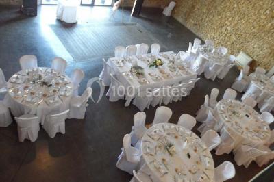 Salle à manger lumineuse avec table en bois, chaises colorées, cuisine ouverte et décoration sobre.