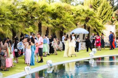 Miniature Location salle Le Coudray-Montceaux (Essonne) - Le Yacht Club du Coudray-Montceaux #10 Un photographe capture une cérémonie sous une pergola décorée de fleurs blanches, entourée de verdure et de rochers.