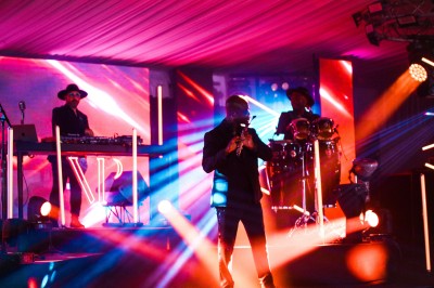 Miniature Location salle Le Coudray-Montceaux (Essonne) - Le Yacht Club du Coudray-Montceaux #12 Un photographe capture une cérémonie sous une pergola décorée de fleurs blanches, entourée de verdure et de rochers.