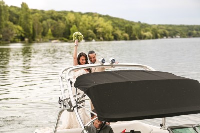 Miniature Location salle Le Coudray-Montceaux (Essonne) - Le Yacht Club du Coudray-Montceaux #18 Un photographe capture une cérémonie sous une pergola décorée de fleurs blanches, entourée de verdure et de rochers.