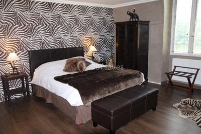 Salle de bain avec une cabine de douche moderne, un banc en bois intégré, deux vasques noires et une fenêtre avec stores.