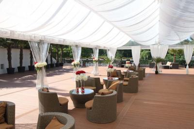 Salle de bain avec une cabine de douche moderne, un banc en bois intégré, deux vasques noires et une fenêtre avec stores.