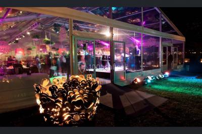 Salle de bain avec une cabine de douche moderne, un banc en bois intégré, deux vasques noires et une fenêtre avec stores.