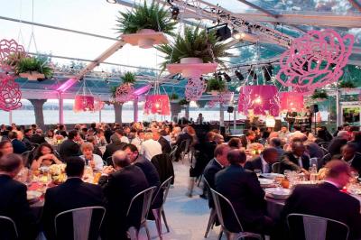 Salle de bain avec une cabine de douche moderne, un banc en bois intégré, deux vasques noires et une fenêtre avec stores.