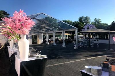 Salle de bain avec une cabine de douche moderne, un banc en bois intégré, deux vasques noires et une fenêtre avec stores.