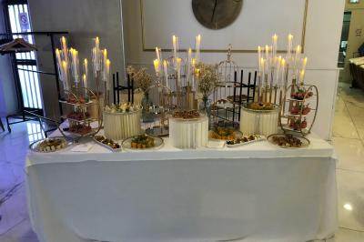 Salle décorée avec des tables rondes dressées, nappes blanches, chaises élégantes et centre de table floral.