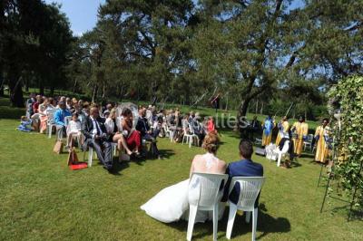 Miniature Location salle Arbonne-la-Forêt (Seine-et-Marne) - Le Domaine du Rocher #22 Allée gravillonnée bordée de verdure et de plantes, menant à une entrée avec des arches blanches sous un ciel dégagé.