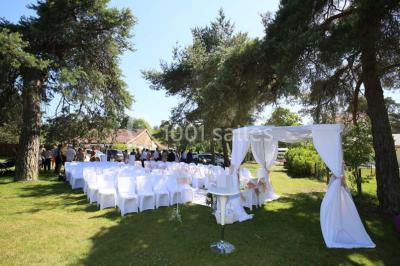 Miniature Location salle Arbonne-la-Forêt (Seine-et-Marne) - Le Domaine du Rocher #1 Allée gravillonnée bordée de verdure et de plantes, menant à une entrée avec des arches blanches sous un ciel dégagé.