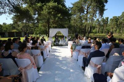 Miniature Location salle Arbonne-la-Forêt (Seine-et-Marne) - Le Domaine du Rocher #2 Allée gravillonnée bordée de verdure et de plantes, menant à une entrée avec des arches blanches sous un ciel dégagé.