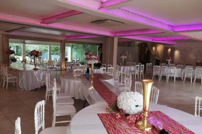 Vue aérienne d'une maison avec toit en tuiles, piscine rectangulaire et jardin arboré dans un cadre rural.