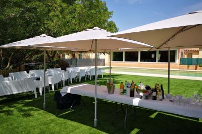 Vue aérienne d'une maison avec toit en tuiles, piscine rectangulaire et jardin arboré dans un cadre rural.