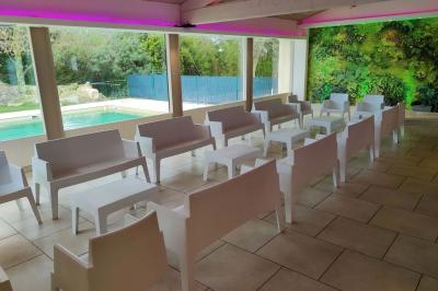 Vue aérienne d'une maison avec toit en tuiles, piscine rectangulaire et jardin arboré dans un cadre rural.