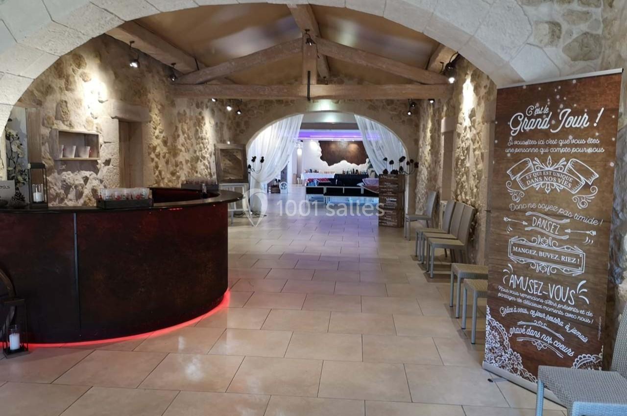 Hall d'accueil avec comptoir en bois sombre, panneaux informatifs et vue sur une salle aménagée en arrière-plan.