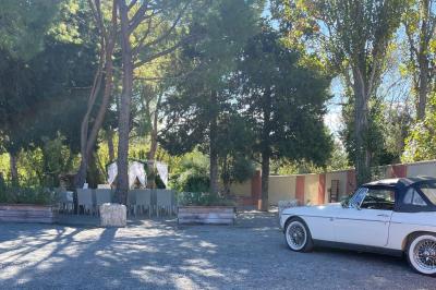Vue aérienne d'une maison avec toit en tuiles, piscine rectangulaire et jardin arboré dans un cadre rural.