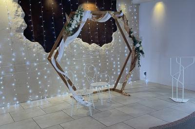 Vue aérienne d'une maison avec toit en tuiles, piscine rectangulaire et jardin arboré dans un cadre rural.
