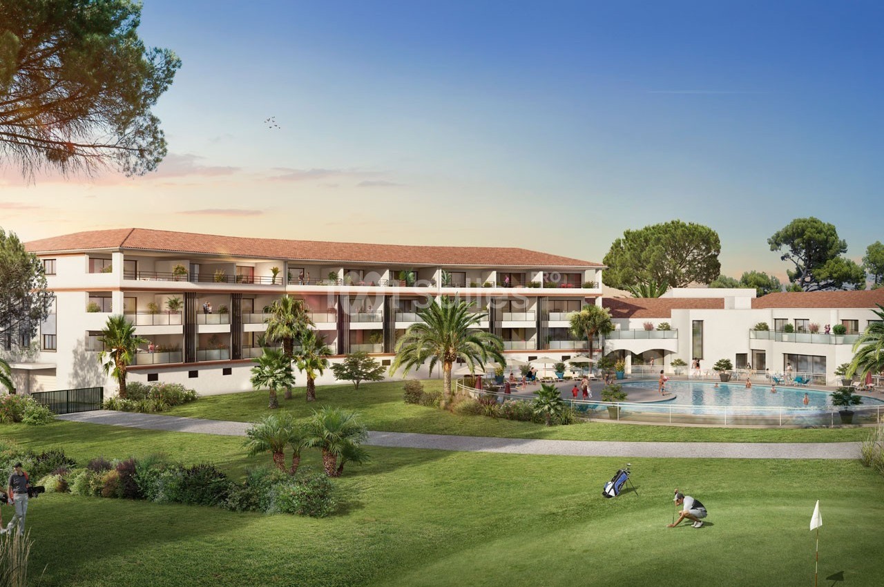 Vue d'un complexe résidentiel avec piscine, espaces verts et architecture méditerranéenne sous un ciel dégagé.