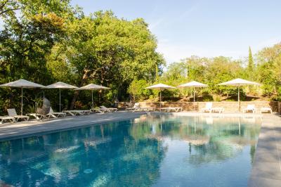 Miniature Location salle Servian (Hérault) - Château Hermitage de Combas #21 Chambre lumineuse avec lit double, tête de lit rouge, murs en pierre, grandes fenêtres et mobilier classique.