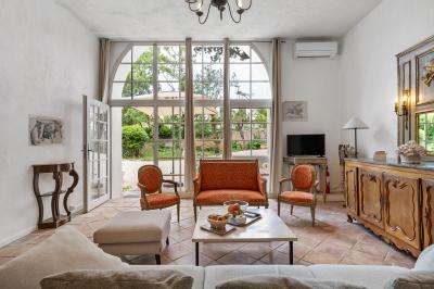 Miniature Location salle Servian (Hérault) - Château Hermitage de Combas #27 Chambre lumineuse avec lit double, tête de lit rouge, murs en pierre, grandes fenêtres et mobilier classique.