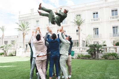 Miniature Location salle Servian (Hérault) - Château Hermitage de Combas #19 Chambre lumineuse avec lit double, tête de lit rouge, murs en pierre, grandes fenêtres et mobilier classique.