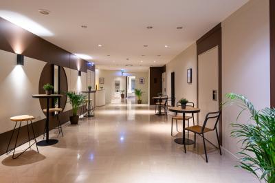 Jacuzzi extérieur entouré de plantes et de chaises longues sur une terrasse avec un panneau en bois.