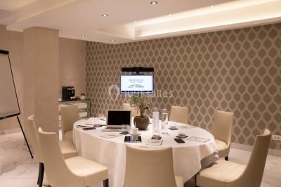 Jacuzzi extérieur entouré de plantes et de chaises longues sur une terrasse avec un panneau en bois.