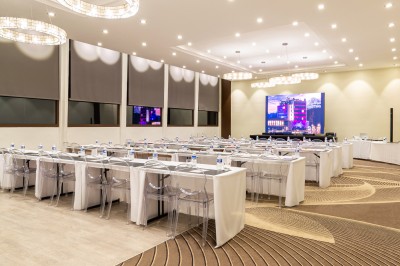 Jacuzzi extérieur entouré de plantes et de chaises longues sur une terrasse avec un panneau en bois.
