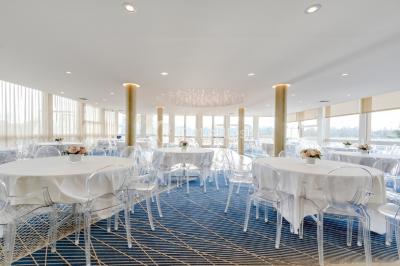 Jacuzzi extérieur entouré de plantes et de chaises longues sur une terrasse avec un panneau en bois.