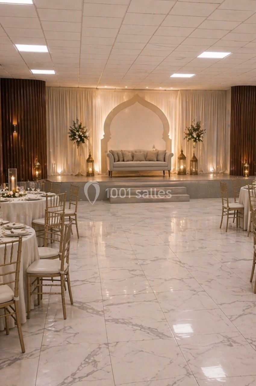 Salle de réception élégante avec tables dressées, chaises dorées et une estrade décorée d'un canapé et d'arches lumineuses.
