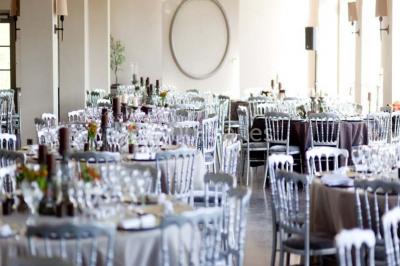 Cour pavée éclairée par des bougies et lumières chaudes, avec un bâtiment historique en arrière-plan, de nuit.