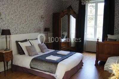 Une chambre d'enfant avec un lit bébé, une table à langer, une chaise haute et des cadres accrochés au mur.