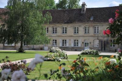 Miniature Location salle Saint-Vaast-lès-Mello (Oise) - Le Clos Barisseuse #2 Cour enneigée avec bâtiments en pierre, un pigeonnier cylindrique et des arbres nus sous un ciel dégagé.