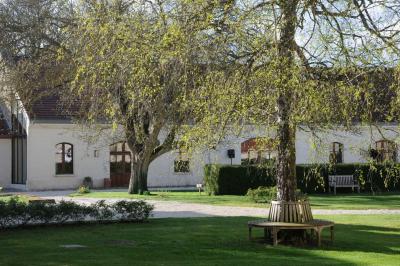Miniature Location salle Saint-Vaast-lès-Mello (Oise) - Le Clos Barisseuse #23 Cour enneigée avec bâtiments en pierre, un pigeonnier cylindrique et des arbres nus sous un ciel dégagé.