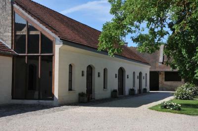 Miniature Location salle Saint-Vaast-lès-Mello (Oise) - Le Clos Barisseuse #31 Cour enneigée avec bâtiments en pierre, un pigeonnier cylindrique et des arbres nus sous un ciel dégagé.