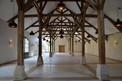 Miniature Location salle Saint-Vaast-lès-Mello (Oise) - Le Clos Barisseuse #7 Cour enneigée avec bâtiments en pierre, un pigeonnier cylindrique et des arbres nus sous un ciel dégagé.
