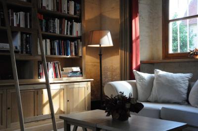 Miniature Location salle Saint-Vaast-lès-Mello (Oise) - Le Clos Barisseuse #40 Cour enneigée avec bâtiments en pierre, un pigeonnier cylindrique et des arbres nus sous un ciel dégagé.