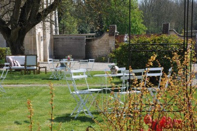 Miniature Location salle Saint-Vaast-lès-Mello (Oise) - Le Clos Barisseuse #22 Cour enneigée avec bâtiments en pierre, un pigeonnier cylindrique et des arbres nus sous un ciel dégagé.
