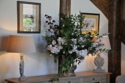 Miniature Location salle Saint-Vaast-lès-Mello (Oise) - Le Clos Barisseuse #47 Cour enneigée avec bâtiments en pierre, un pigeonnier cylindrique et des arbres nus sous un ciel dégagé.