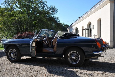 Miniature Location salle Saint-Vaast-lès-Mello (Oise) - Le Clos Barisseuse #48 Cour enneigée avec bâtiments en pierre, un pigeonnier cylindrique et des arbres nus sous un ciel dégagé.