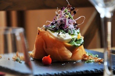 Miniature Location salle Saint-Vaast-lès-Mello (Oise) - Le Clos Barisseuse #26 Cour enneigée avec bâtiments en pierre, un pigeonnier cylindrique et des arbres nus sous un ciel dégagé.