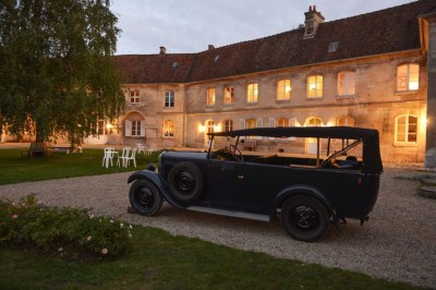 Miniature Location salle Saint-Vaast-lès-Mello (Oise) - Le Clos Barisseuse #24 Cour enneigée avec bâtiments en pierre, un pigeonnier cylindrique et des arbres nus sous un ciel dégagé.