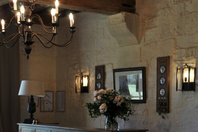 Miniature Location salle Saint-Vaast-lès-Mello (Oise) - Le Clos Barisseuse #43 Cour enneigée avec bâtiments en pierre, un pigeonnier cylindrique et des arbres nus sous un ciel dégagé.