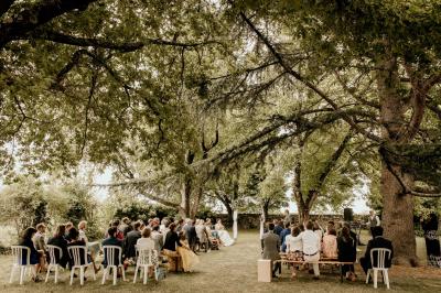 Miniature Location salle Rions (Gironde) - Domaine Pascaud #6 Salle de réception lumineuse avec tables rondes dressées, nappes blanches, chaises en bois et décorations florales.
