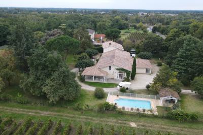 Miniature Location salle Rions (Gironde) - Domaine Pascaud #7 Salle de réception lumineuse avec tables rondes dressées, nappes blanches, chaises en bois et décorations florales.