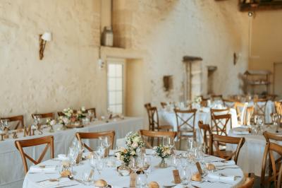 Miniature Location salle Rions (Gironde) - Domaine Pascaud #17 Salle de réception lumineuse avec tables rondes dressées, nappes blanches, chaises en bois et décorations florales.