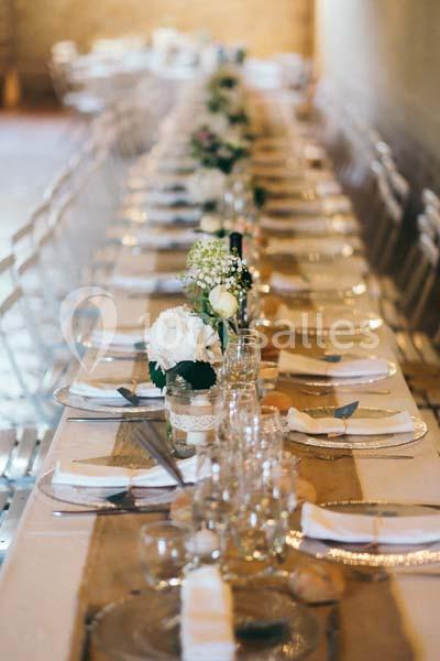 Location salle Pomérols (Hérault) - Domaine Fon de Rey #5 Table longue décorée pour un événement, avec nappes blanches, fleurs et vaisselle disposées de manière élégante.