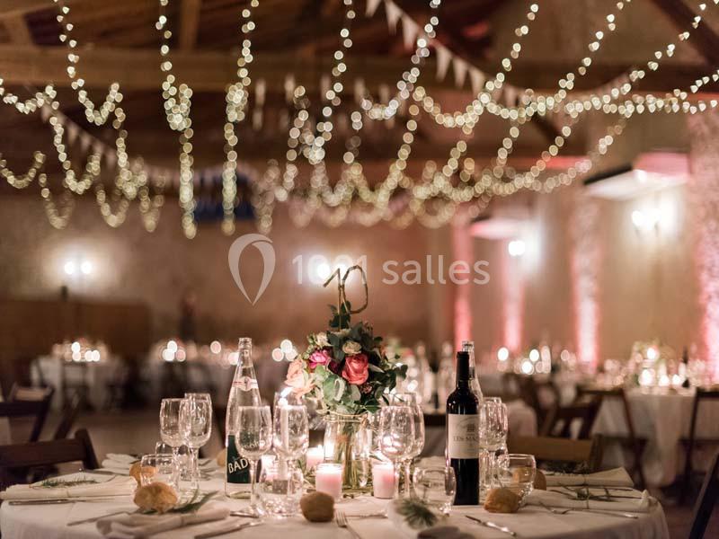 Location salle Pomérols (Hérault) - Domaine Fon de Rey #4 Salle de réception décorée avec des guirlandes lumineuses, tables dressées avec fleurs, bougies et bouteilles de vin.